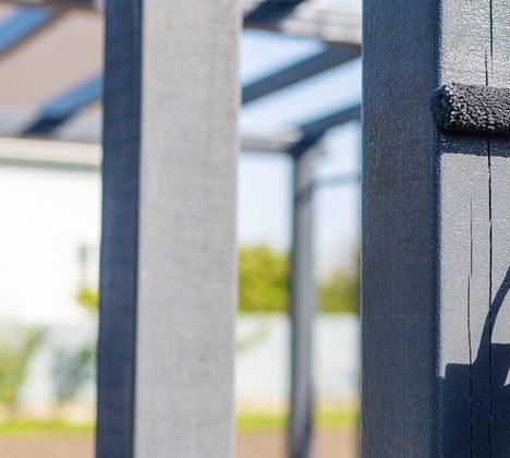 Pergola posts taking a dark charcoal coat over gray primer