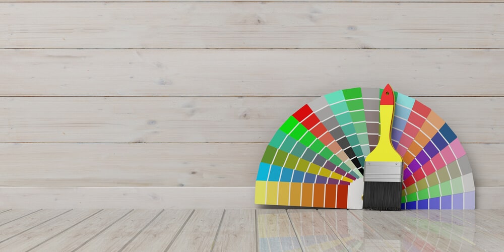 Color fan and brush resting on painted white timber
