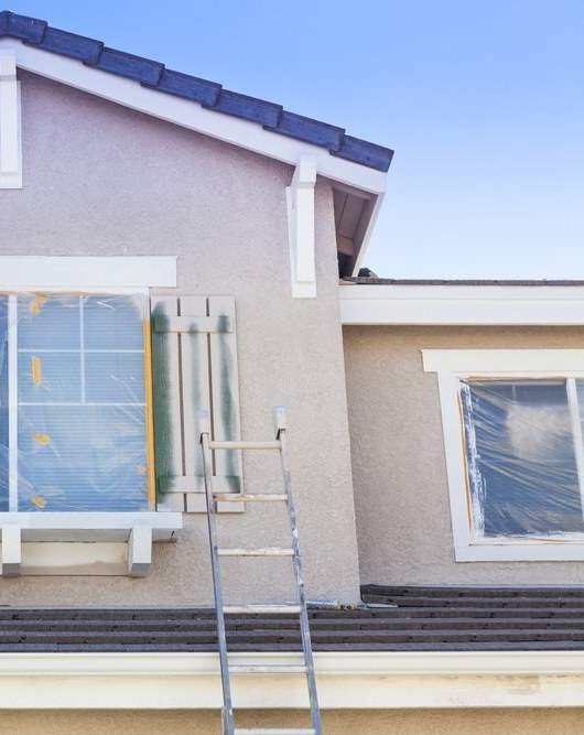 Window masked off under plastic with a shutter and the trim cut in around it