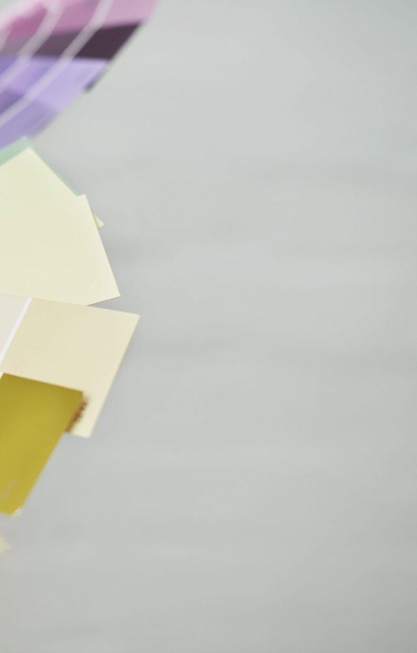 Paint swatch cards fanned out against a gray wall