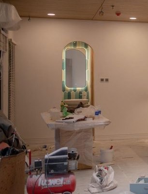 Backlit mirror over a vanity in a room mid refurbishment