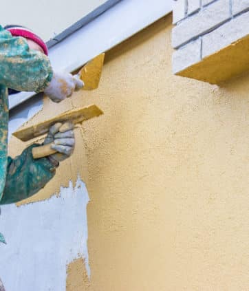Builder worker plastering exterior wall, facade plasterer at work - Big Easy Paintings